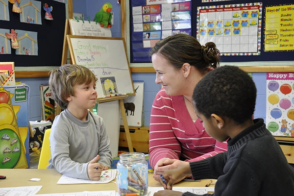 Learning Paths Academy is now hiring! Daycare careers include teachers, management, support staff, and other childcare jobs. Image of teacher and students smiling at each other.