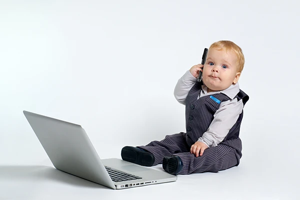 Contact the Learning Paths Academy - cute baby in business attire on phone at a computer