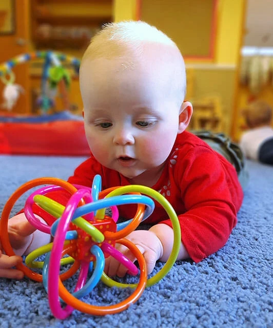 Cute baby engaged with toy - Learning Paths Academy Baby Steps infant daycare program