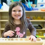 Learning Paths Academy has blended Montessori preschool - smiling girl working with educational Montessori equipment