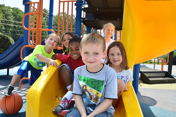 Youth Zone school age care - children on playground / slide having fun together at Learning Paths Academy