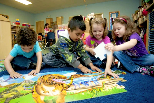 Junior Kindergarten students having fun assembling floor puzzle together - Learning Paths Academy